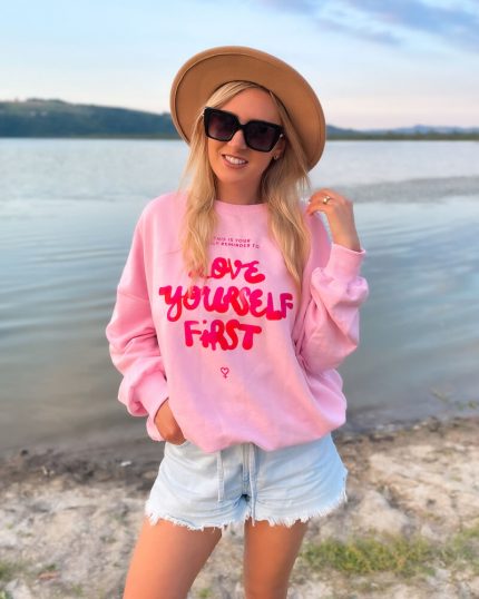 Bluza Damska Bawełniana Oversize z napisem Love Yourself First w kolorze pudrowego różu prezentowana przez młodą dziewczynę