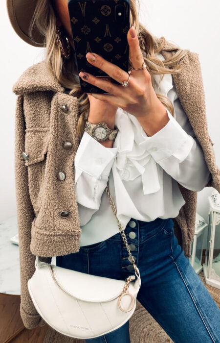 Kobieta prezentuje białą elegancką koszulę i kurteczkę Teddy