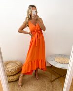 Młoda dziewczyna ubrana w długą sukienkę w pomarańczowym kolorze