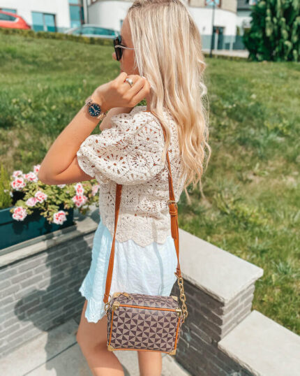 Torebka listonoszka w kolorze brązowym prezentowana przez młodą dziewczynę