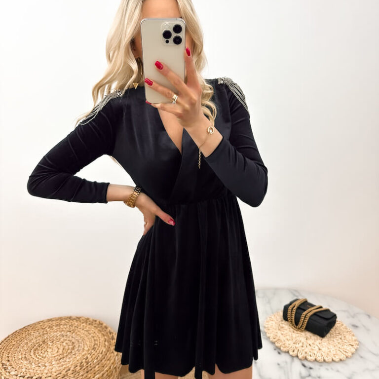 Sukienka welurowa czarna z ozdobnymi pagonami o długości mini prezentowana przez młodą dziewczynę