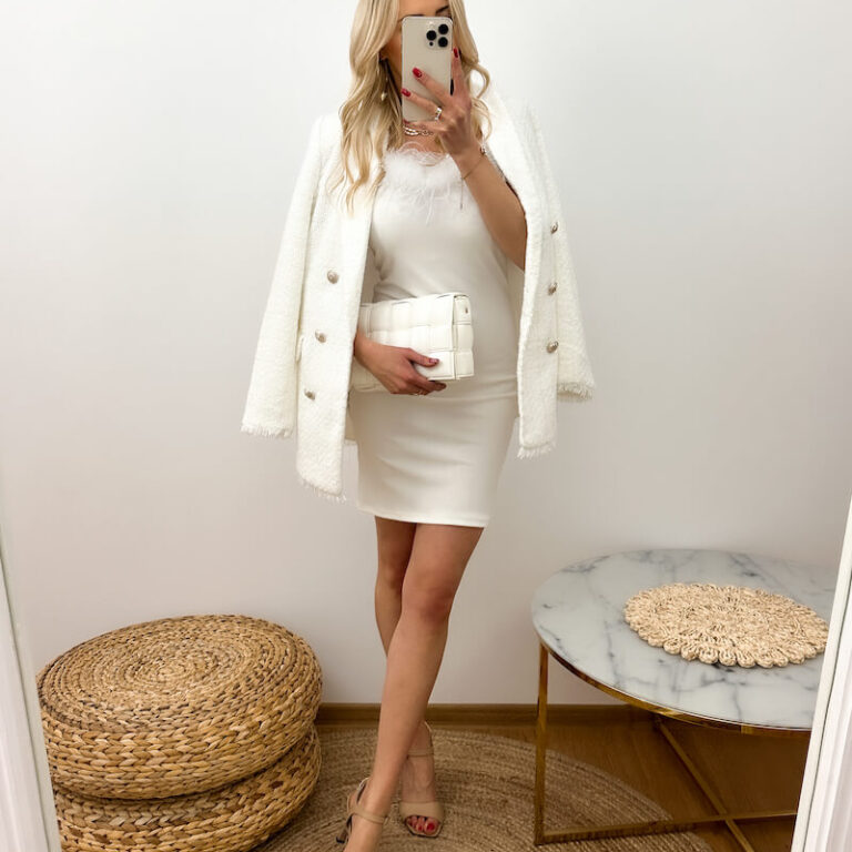 Sukienka z piórami biała prezentowana przez młodą dziewczynę o długości mini