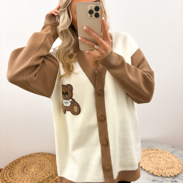 Sweter damski z misiem ecru na guziki prezentowany przez młodą dziewczynę