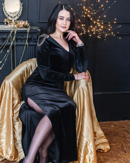 Sukienka welurowa czarna maxi z pagonami prezentowana przez elegancką kobietę