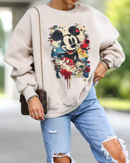 Beżowa bluza z myszką miki oversize bawełniana prezentowana przez młodą dziewczynę w stylizacji miejskiej