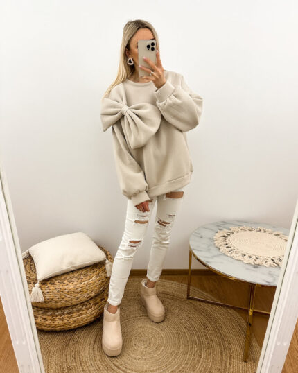 bluza z kokarda beżowa prezentowana w codziennej stylizacji przez młodą dziewczynę