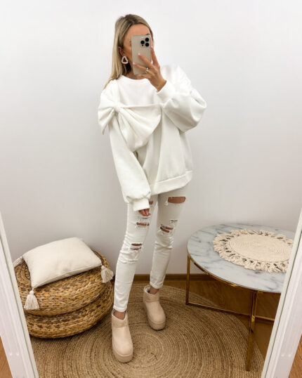 bluza z kokardą biała, oversize prezentowana w codziennej stylizacji przez młodą dziewczynę