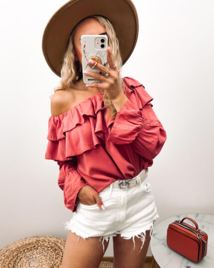 Bluzka hiszpanka koralowa w stylu boho prezentowana przez młodą dziewczynę