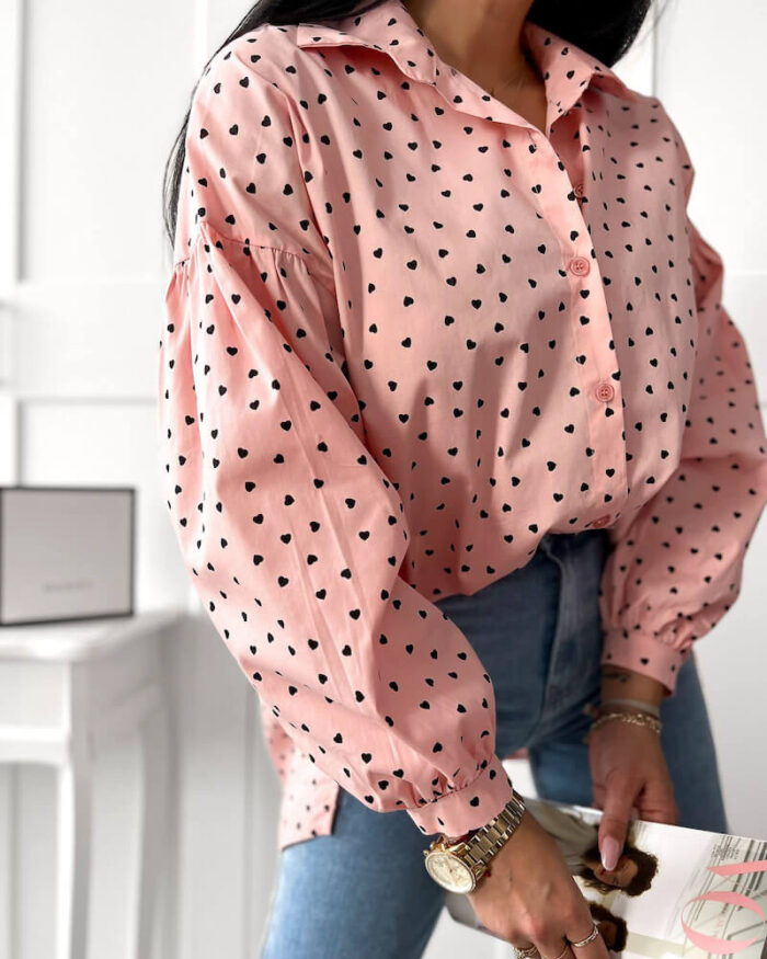 Różowa koszula w serduszka oversize asymetryczna prezentowana przez młodą dziewczynę