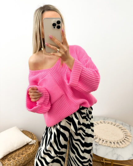 Różowy sweter damski dekolt V z kieszenią oversize prezentowany przez młodą dziewczynę