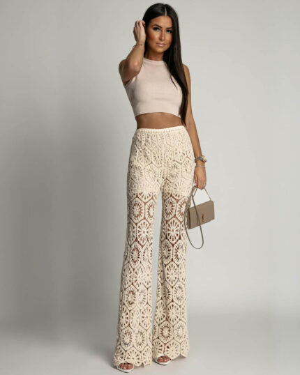 Bezowe spodnie ażurowe boho typu dzwony prezentowane przez młodą dziewczynę