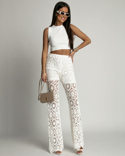 Białe spodnie ażurowe boho typu dzwony prezentowane przez młodą dziewczynę