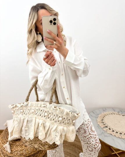 Koszyk plażowy z perełkami i koronką boho z trawy morskiej prezentowany przez młodą dziewczynę