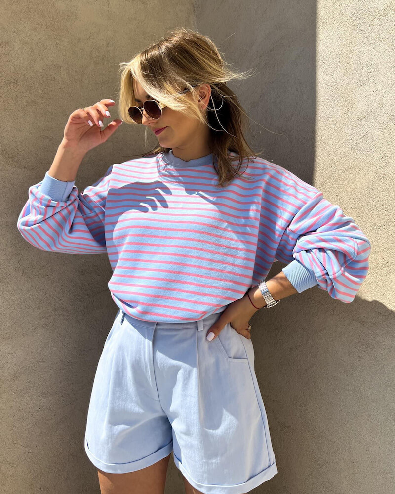 niebieska bluza w paski oversize bawełniana Niebieska bluza w paski bawełniana oversize prezentowana przez młodą dziewczynę