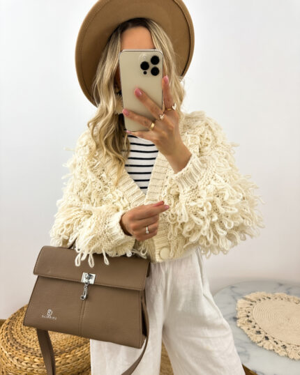 Beżowa torebka kuferek prezentowana przez młodą dziewczynę