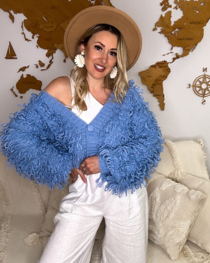 Niebieski kardigan z frędzlami boho prezentowany przez młodą dziewczynę
