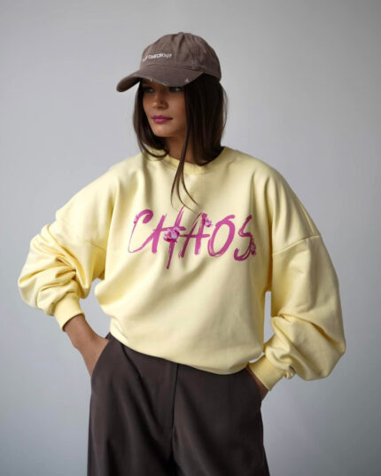 Bananowa bluza overisze z napisem CHAOS prezentowana przez młodą dziewczynę